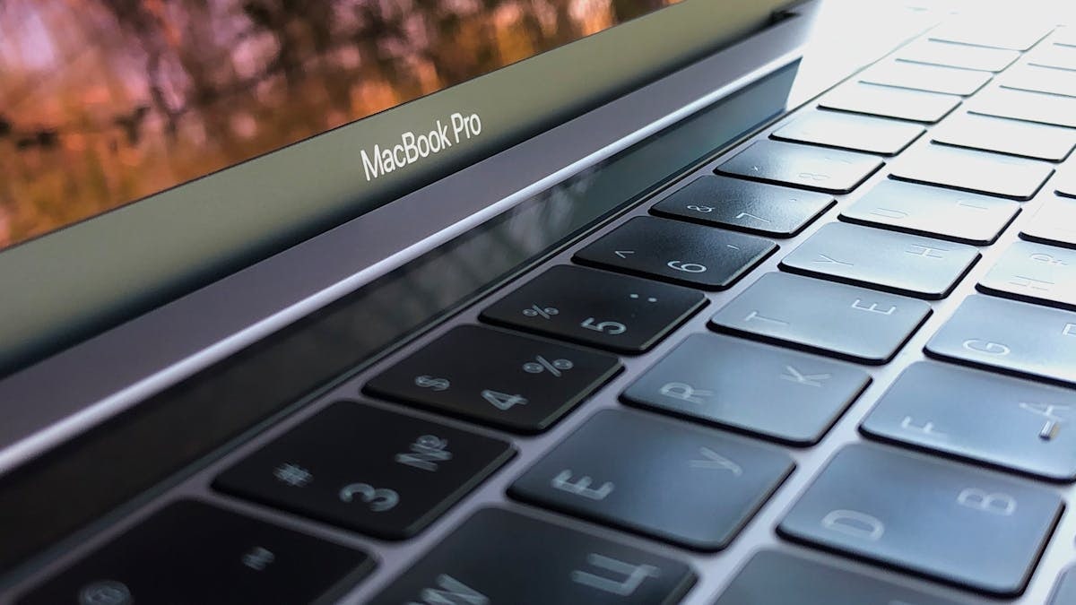 A detailed close-up of a MacBook Pro keyboard, highlighting keys and reflection.